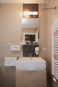 a bathroom with a white sink and a mirror at Hotel Green in Dolný Kubín +54 photos