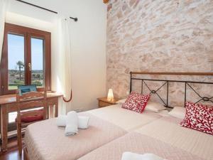 a bedroom with two beds with red and white pillows at S'hort d'en Bonet in Santanyi +27 photos