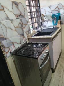 a kitchen with a stove and a counter top at AJALA Lodge in Badagry