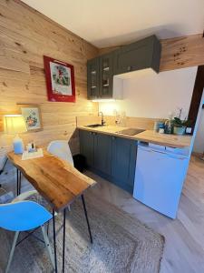 a kitchen with a table and a counter top at Grand Studio Cocon & Spa in Mosnay +11 photos
