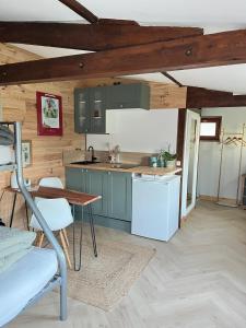 a kitchen with blue cabinets and a table in a room at Grand Studio Cocon & Spa in Mosnay