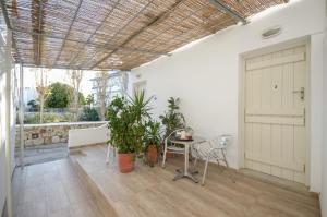 a room with a table and chairs and a door at Depis suites naxos in Naxos Chora