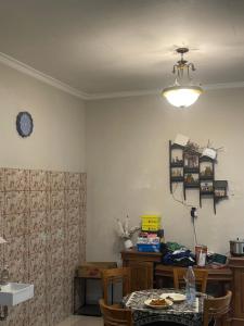a dining room with a table and a clock on the wall at Leon Mansion in Pulau Layang