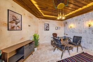 a room with a table and chairs and a stone wall at Pegas Goreme in Göreme +30 photos
