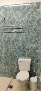a bathroom with a white toilet and a marble wall at abpikermistudios3 in Pikérmion