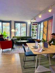 a living room with people sitting in chairs and tables at Sigma Self Check-in Hostel in Zurich