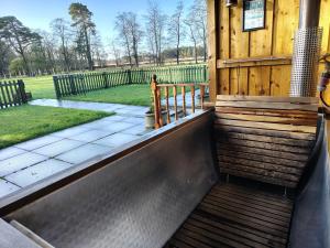 a porch of a wooden house with a fence at West Stable Cottage in Cameron