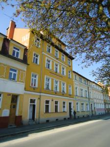ein gelbes Gebäude an der Straßenseite in der Unterkunft Apartment Harmonia in Franzensbad