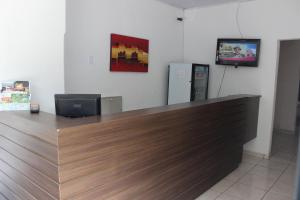 a cashier counter in a store with a television at Pousada Vila Pitanga in Santos