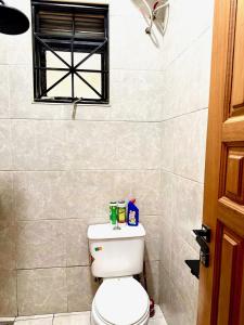a bathroom with a white toilet with a window at Sky world homes in Kampala +5 photos