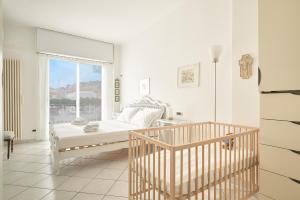 a white bedroom with a bed and a window at SottoVento in Imperia