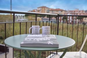 two coffee cups and a book on a table on a balcony at SottoVento in Imperia