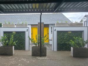 ein Gebäude mit zwei Garagentoren und zwei Topfpflanzen in der Unterkunft Leipoldt Self-Catering Accommodation in Secunda
