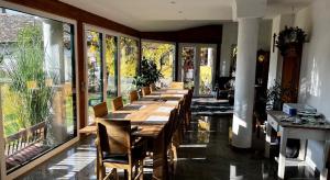 a long wooden table in a room with windows at Gästehaus Weinwurm in Obritz