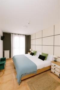 a bedroom with a large bed and a green chair at Amari in Getaria +41 photos