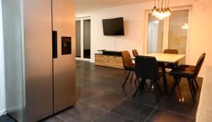 a dining room with a table and a refrigerator at Monteurunterkunft Lüneburg bis 18 Personen drei Häuser nebeneinander Parkplatz WLAN in Artlenburg
