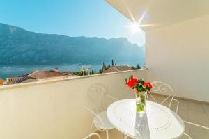 a table with a vase of flowers on a balcony at Relaxing 2 bedroom apartment with Bay View and Parking in Prčanj