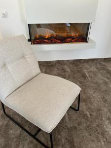 a white chair sitting in front of a fireplace at Galerie Hotel in Bad Reichenhall