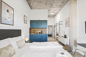 a bedroom with a bed and a kitchen with blue cabinets at SKYRISE Apartments mit Küche, WLAN & Parkplatz - ruhige Lage in Bad Wörishofen