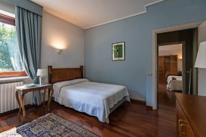 a bedroom with a bed and a table and a window at Villa La Fortezza in Dormelletto +33 photos