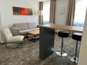 a living room with a couch and a table and chairs at Galerie Hotel in Bad Reichenhall