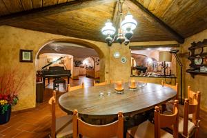 a dining room with a wooden table and a piano at Villa La Fortezza in Dormelletto