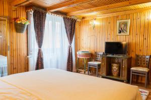 a bedroom with a bed and a flat screen tv at SemiLuna in Buşteni