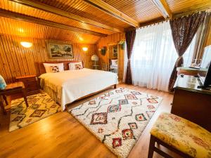 a bedroom with a bed and a rug at SemiLuna in Buşteni
