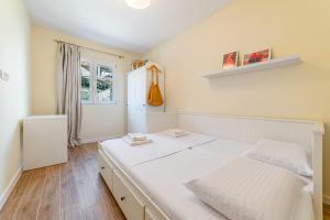 a bedroom with a white bed and a window at Relaxing 2 bedroom apartment with Bay View and Parking in Prčanj