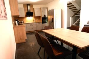 a kitchen with a wooden table and some chairs at Monteurunterkunft Lüneburg bis 18 Personen drei Häuser nebeneinander Parkplatz WLAN in Artlenburg