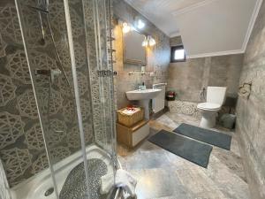 a bathroom with a shower and a sink and a toilet at SemiLuna in Buşteni +39 photos