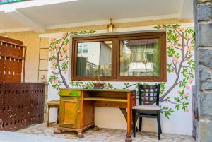 a desk and a chair next to a wall with a window at SemiLuna in Buşteni