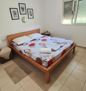 a bedroom with a bed with a blue comforter at Hotel Gonaj in Velipojë