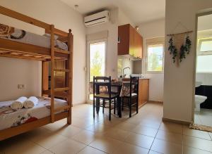 a room with bunk beds and a table and a kitchen at Hotel Gonaj in Velipojë