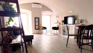 a living room with a tv and a table and chairs at Nene's Home in Sanremo