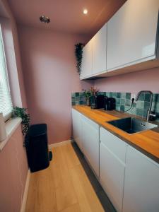 a kitchen with white cabinets and a sink at B&B 't Herfter Erf in Zwolle