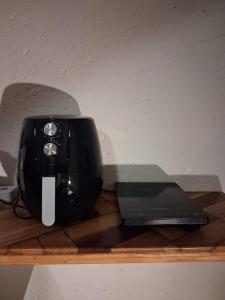 a black toaster and a laptop on a wooden shelf at Die Eend Studio in Centurion