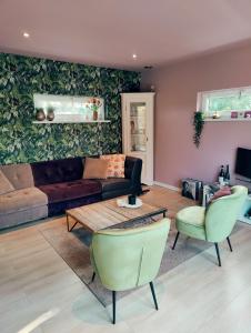 a living room with a couch and a table and chairs at B&B 't Herfter Erf in Zwolle +1 photo