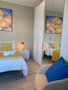 a bedroom with two beds and a mirror at Top Lake View in Faggeto Lario 