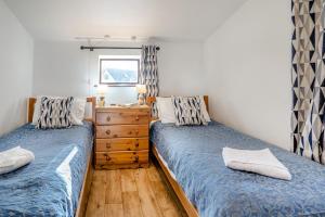 a bedroom with two beds and a dresser and a window at 2 Bed in Risca oc-b35977 in Risca