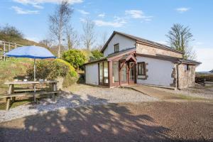 a house with an umbrella and a picnic table at 2 Bed in Risca oc-b35977 in Risca