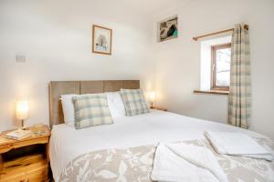 a bedroom with a large white bed and a window at 2 Bed in Risca oc-h35978 in Risca