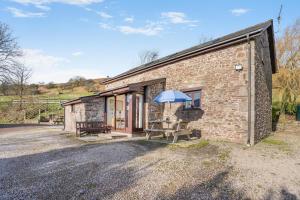 a stone cottage with a blue umbrella outside at 2 Bed in Risca oc-h35978 in Risca