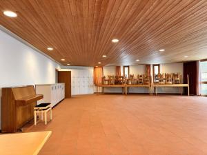 a large room with a wooden ceiling in a library at Abenteuer Turm in Braunwald