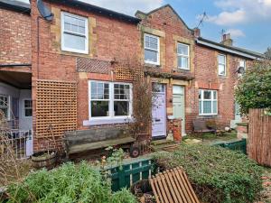 a brick house with a bench in front of it at 2 Bed in Morpeth oc-l35201 in Morpeth