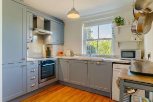 a kitchen with blue cabinets and a window at 3 Bed in Reydon oc-a36049 in Reydon