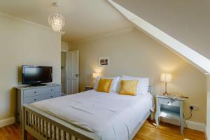 a bedroom with a white bed and a tv at 3 Bed in Reydon oc-a36049 in Reydon
