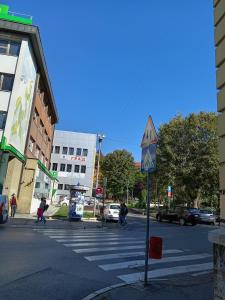 a street with a crosswalk with people crossing the street at Konačište Grad B&B in Užice