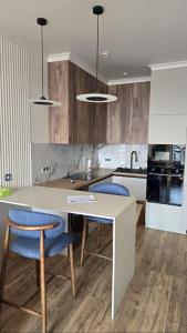a kitchen with a table and two blue chairs at Snow Leopard Residence in Osh
