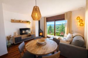 a living room with a table and a couch at Allotjaments Vall de Muntanyes in Molló